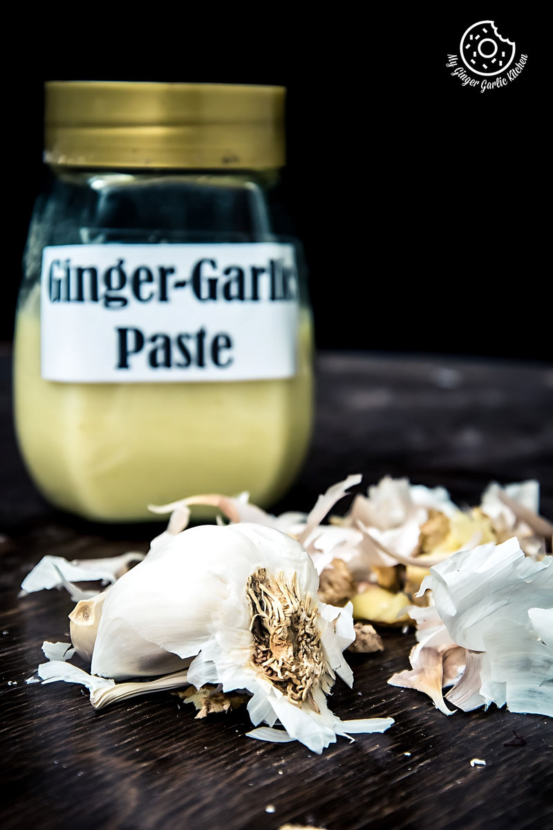 a jar of homemade ginger garlic paste next to garlic