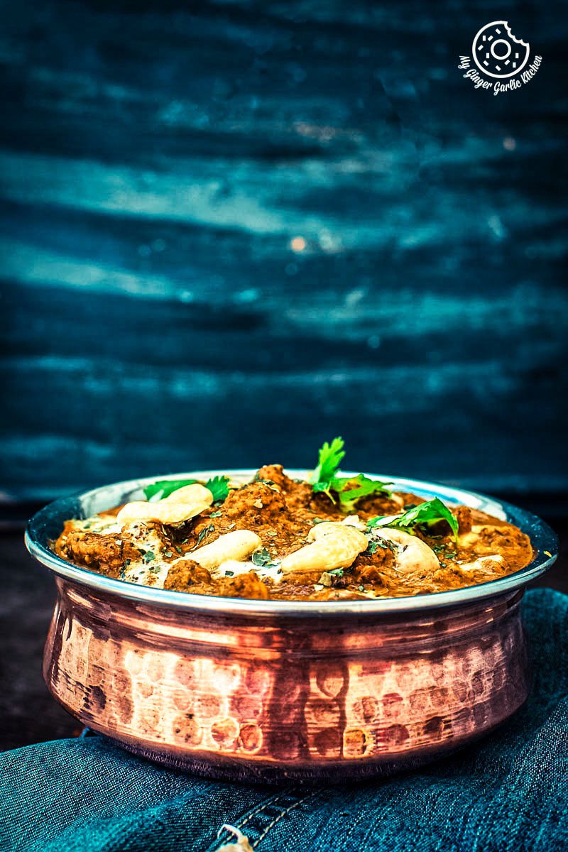 a large metal bowl with restaurant style shahi kaju curry in it on a table