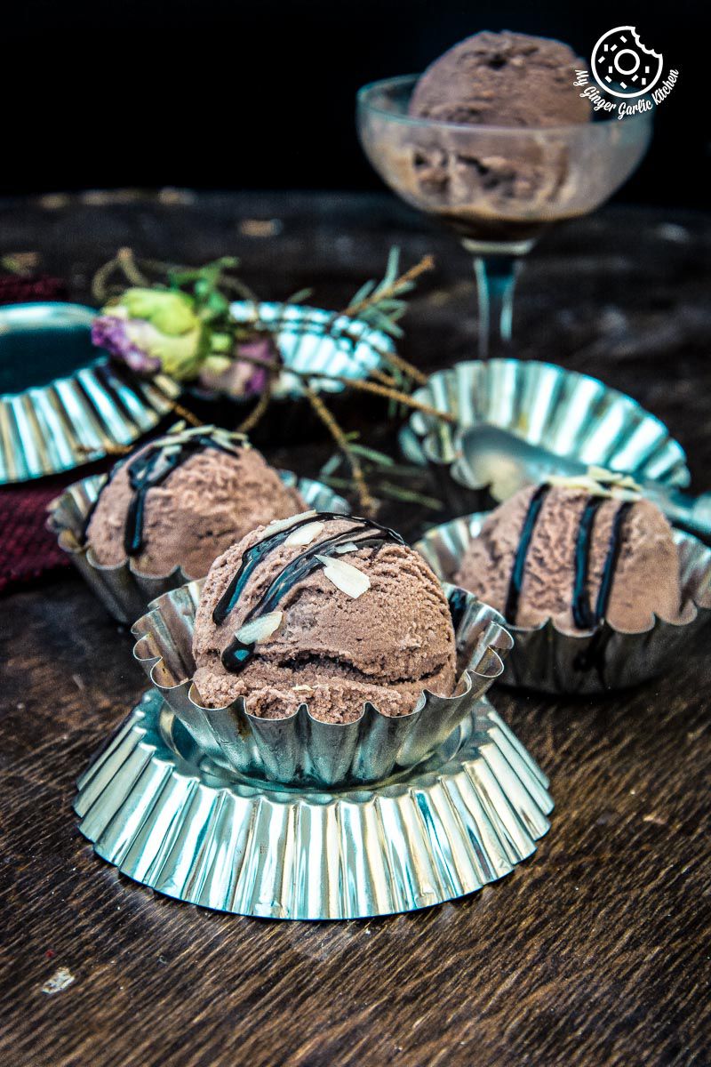 three cups of eggless chocolate hazelnut ice cream on a table with a glass