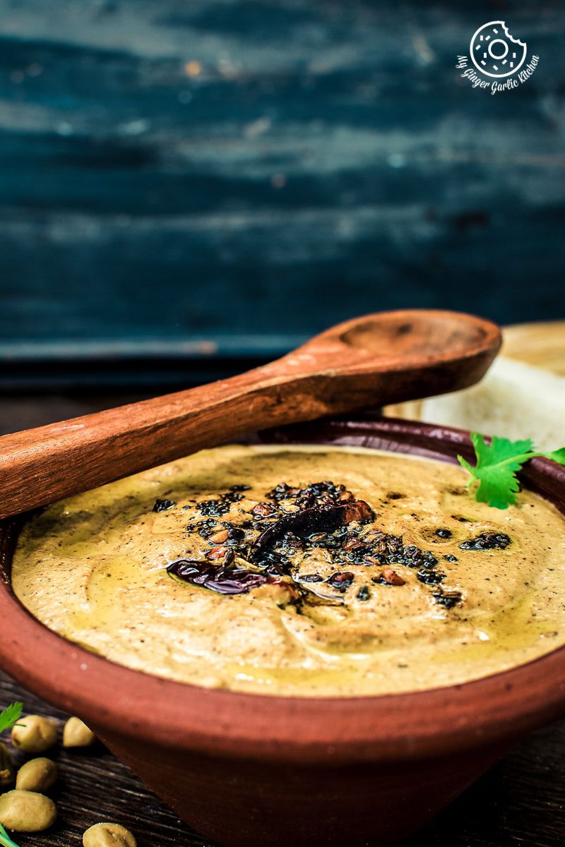 a bowl of south indian style peanut garlic chutney with a wooden spoon 