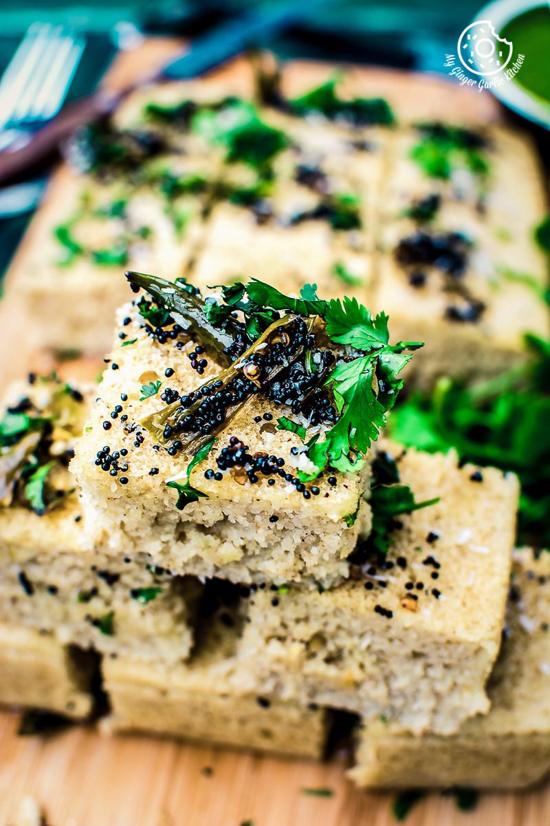 a wooden cutting board with a instant oats rava dhokla on it