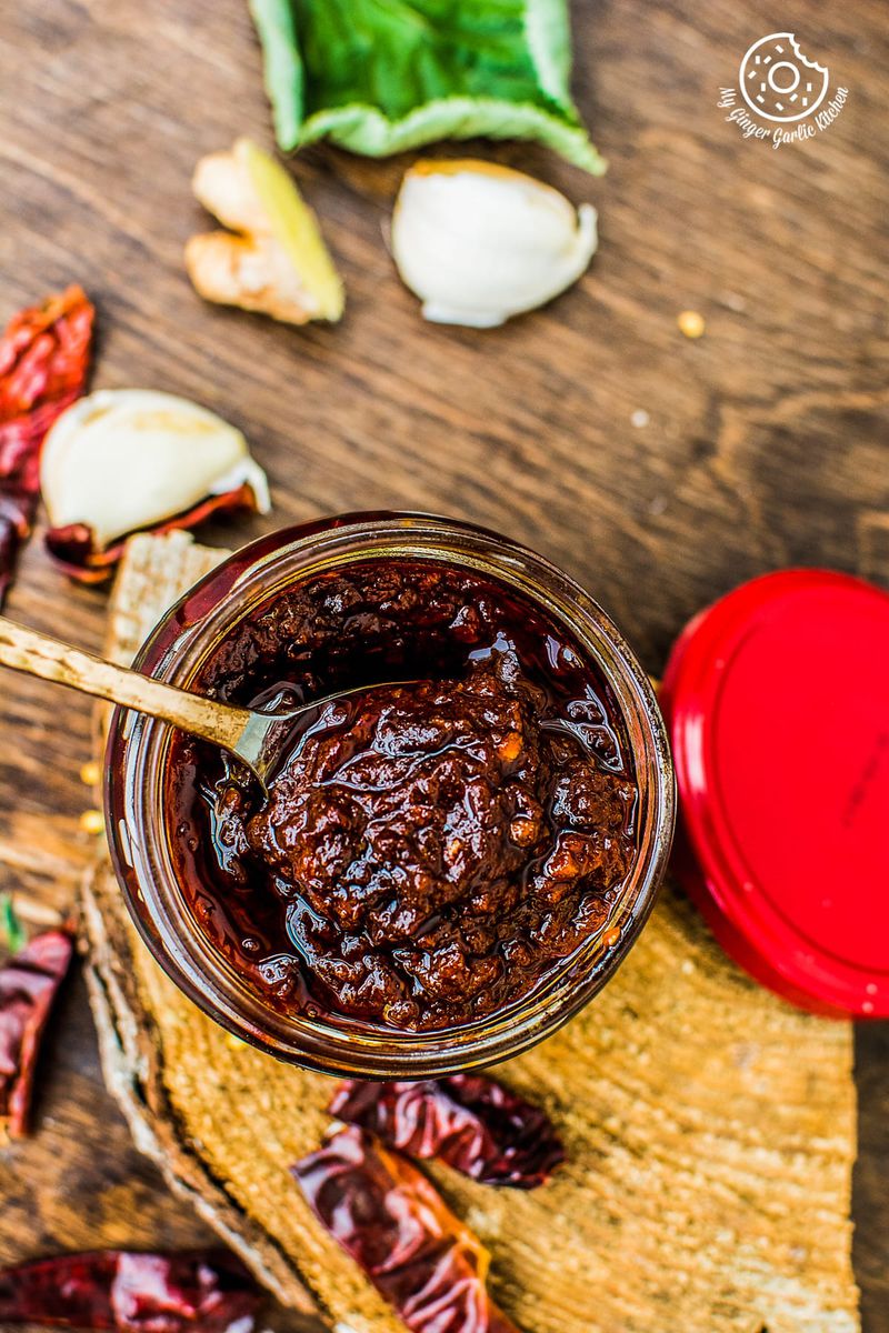 a jar of schezwan sauce or chili paste on a cutting board