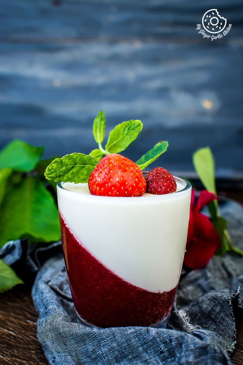 a strawberry panna cotta with strawberries and cream in a glass