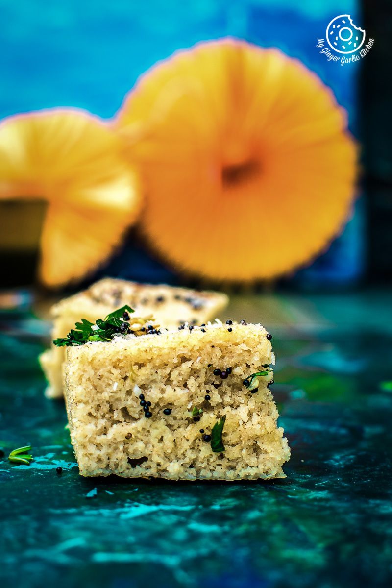 a piece of instant oats rava dhokla that is sitting on a table