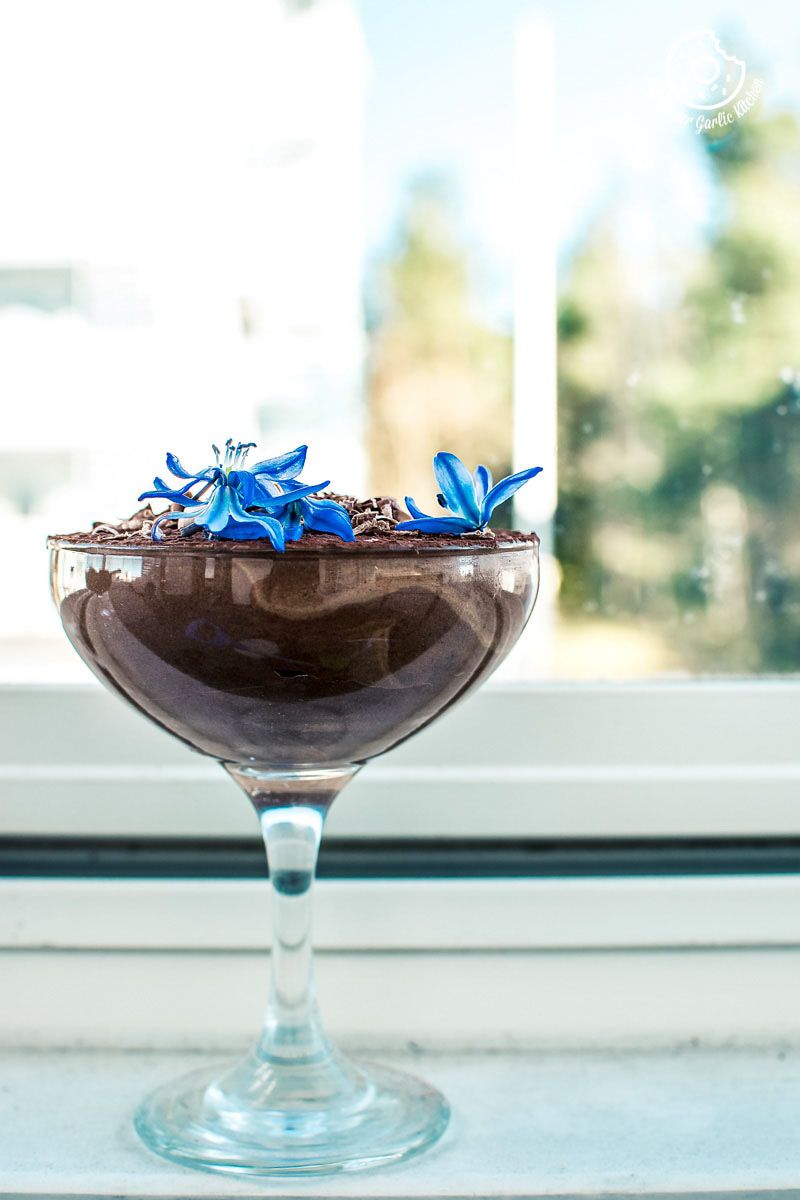 a vegan aquafaba chocolate mousse in a glass on a window sill
