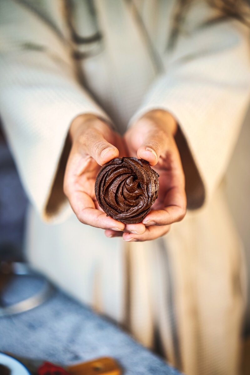 Person holding a single chocolate cookie close up, homemade chocolate cookies recipe, soft and chewy chocolate swirl cookie, perfect treat for chocolate lovers