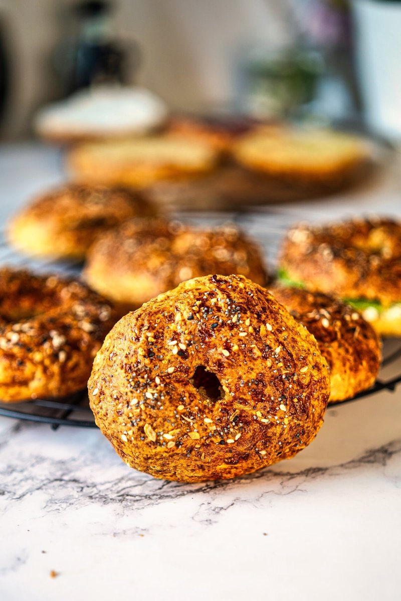 Golden brown homemade 2 ingredient cottage cheese bagel topped with everything bagel seasoning on a cooling rack.