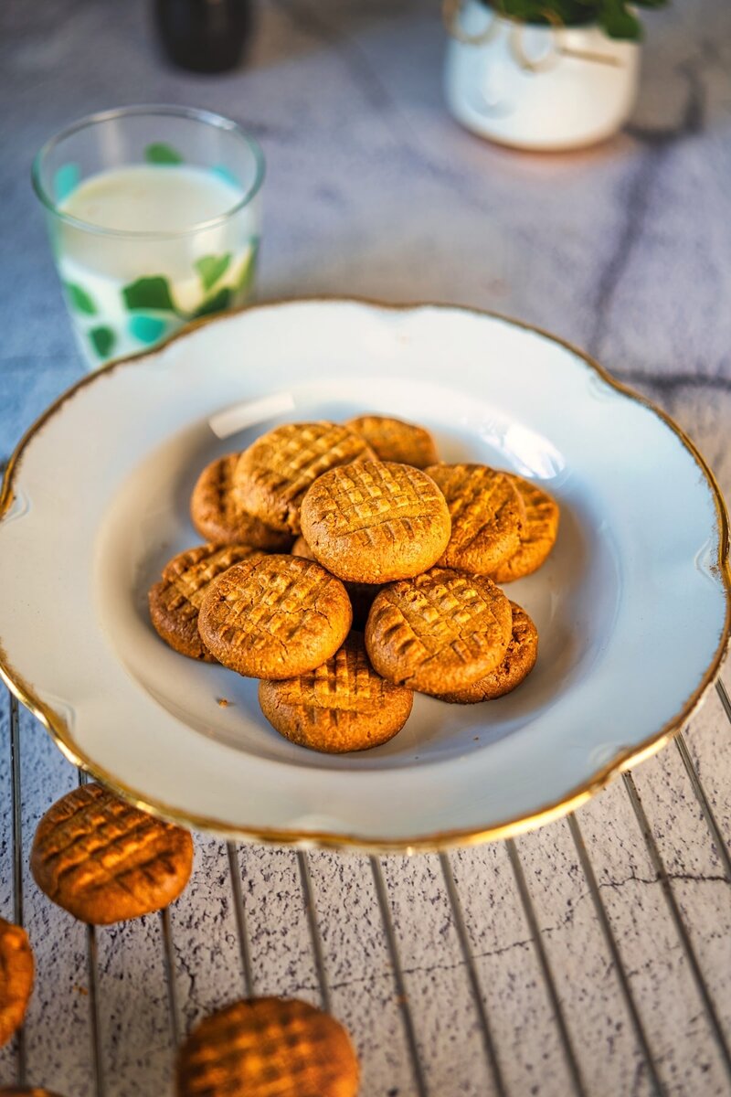Batch of easy 2-ingredient peanut butter cookies in elegant bowl and glass of milk in background, perfect snack