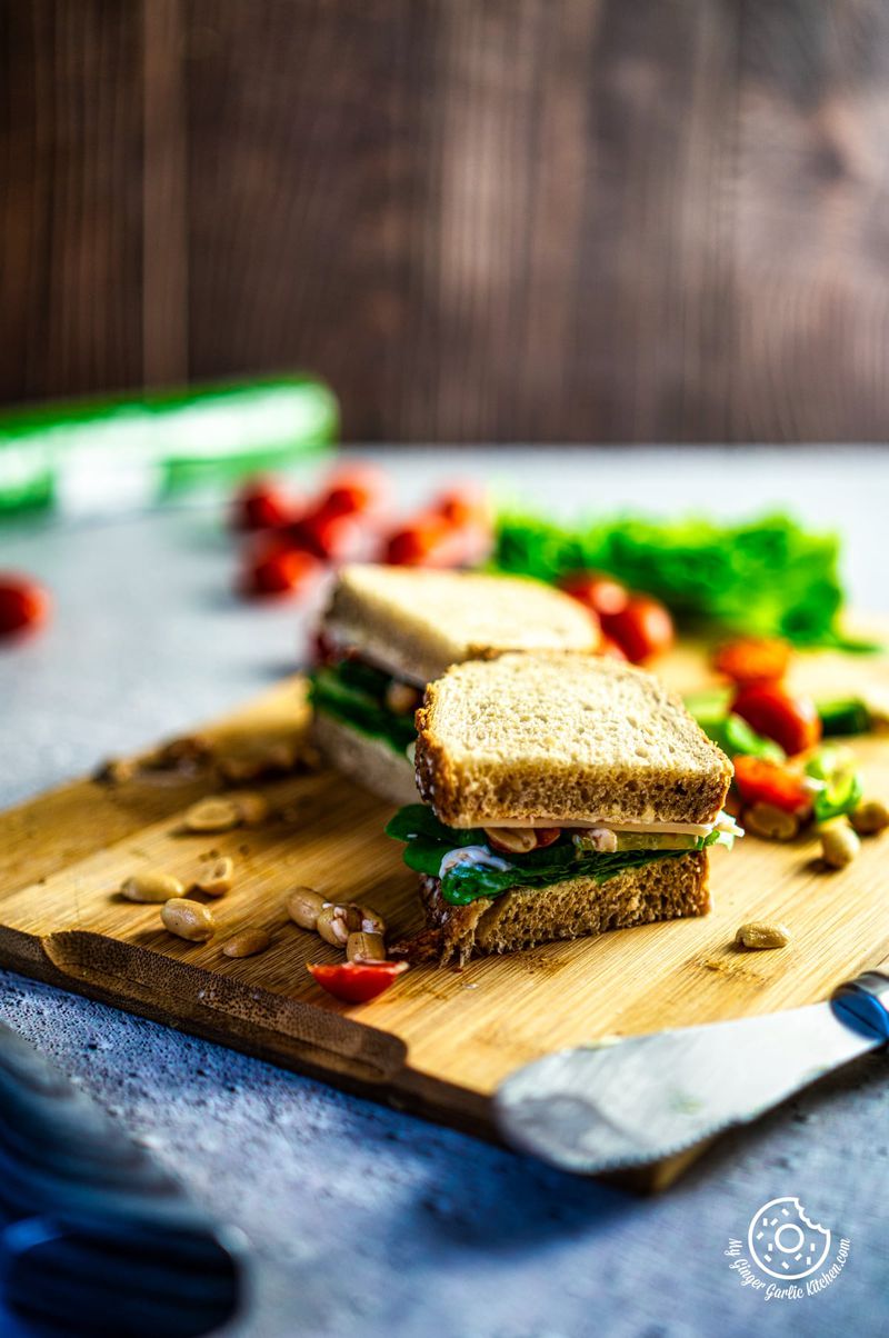 a sliced 2-minute veggie sandwich kept on a wooden board