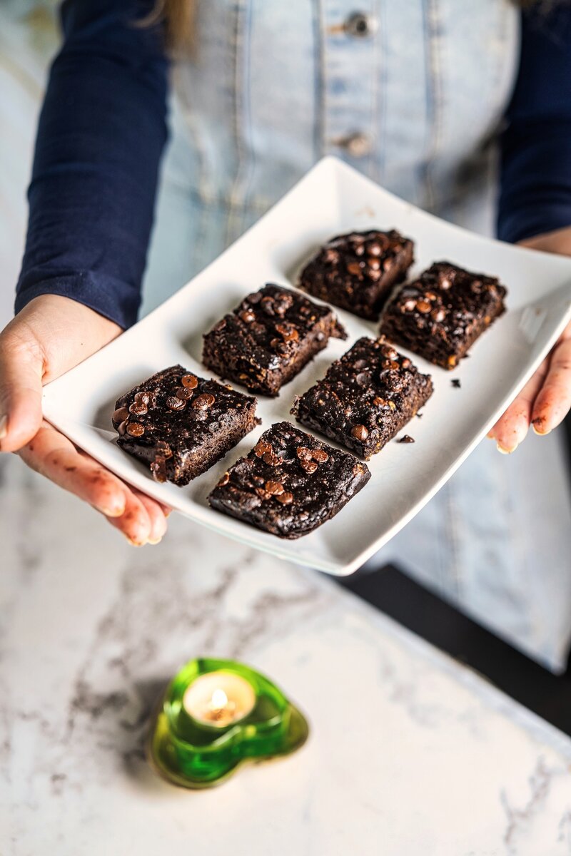 Plate of sliced vegan banana peanut butter brownies served as a healthy chocolate dessert