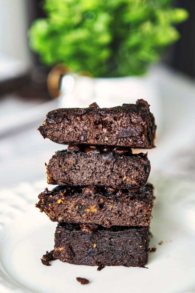 Close-up of fudgy banana peanut butter brownies stacked on a plate showing moist, flourless crumb