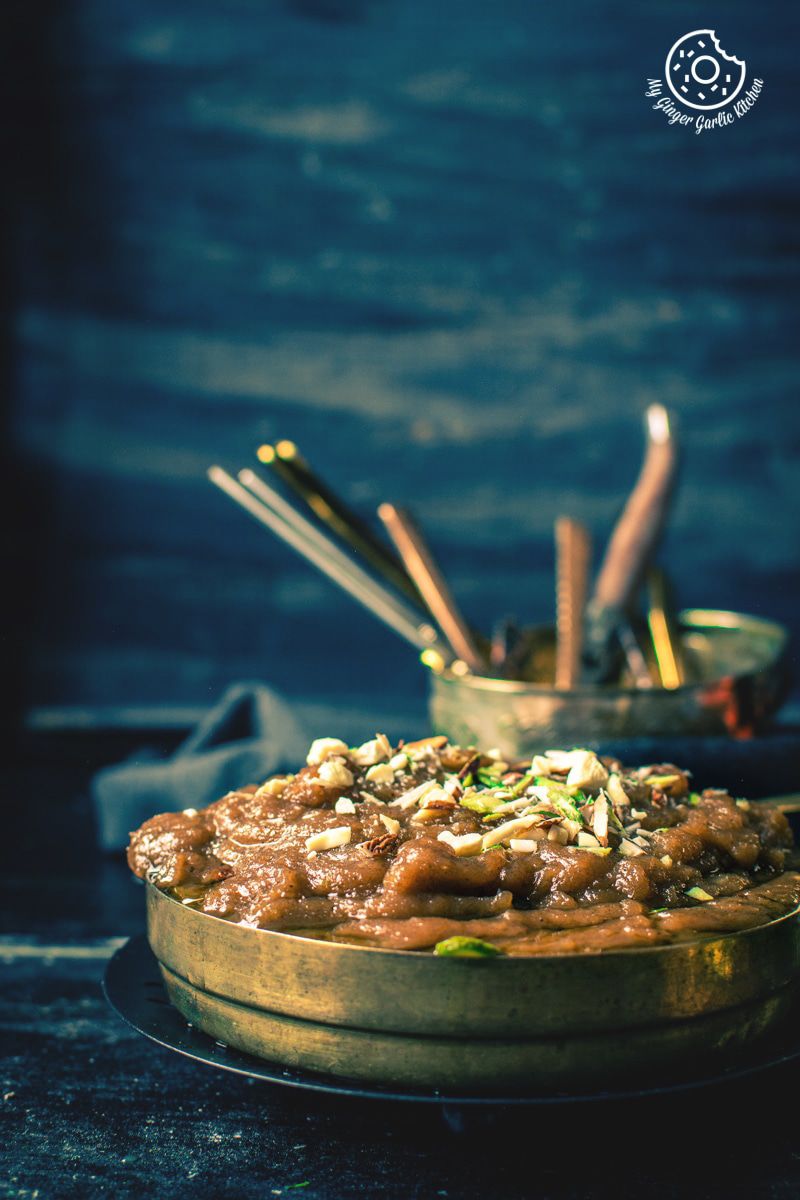 a bowl of aate ka halwa on a table with a spoon