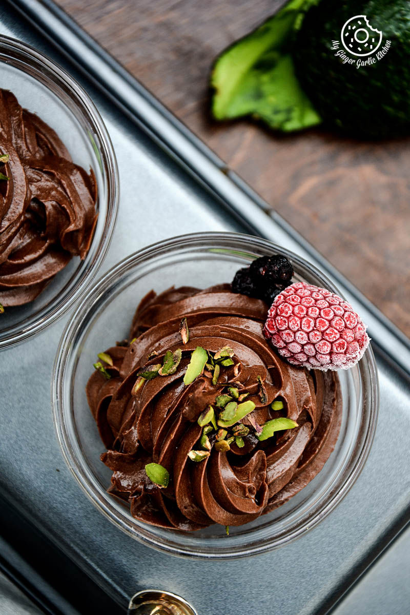 two avocado chocolate mousse in small bowls on a tray
