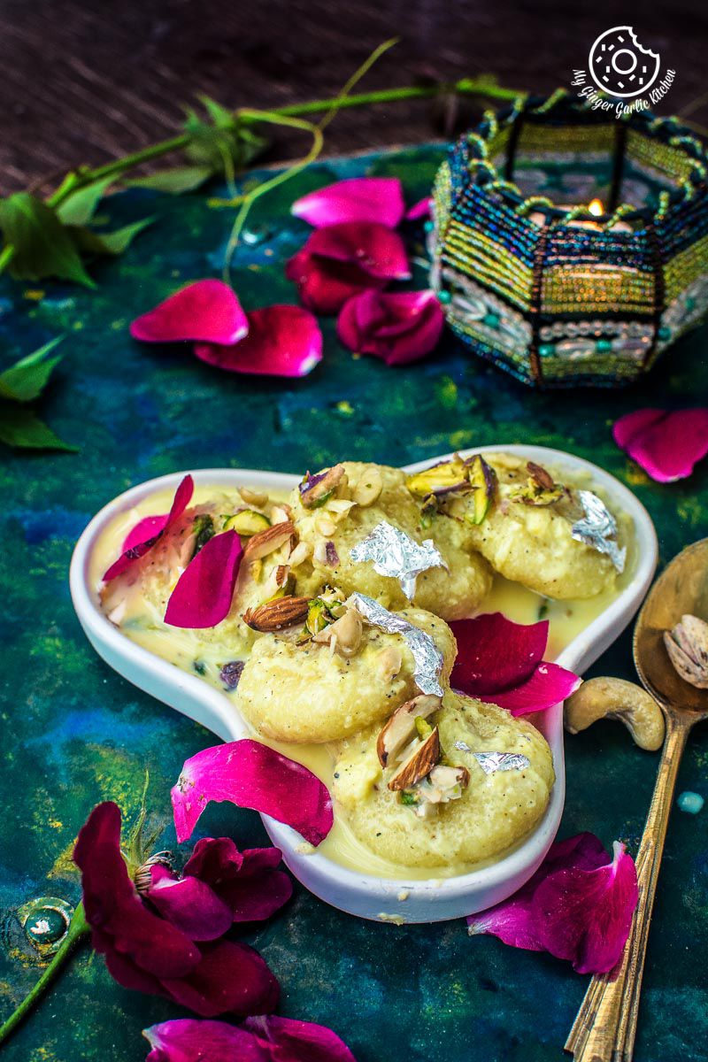 two bowls of soft ras malai on a table with flowers
