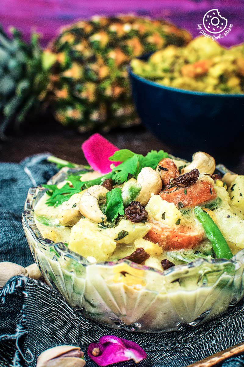 a bowl o navratan korma with a pineapple in the background