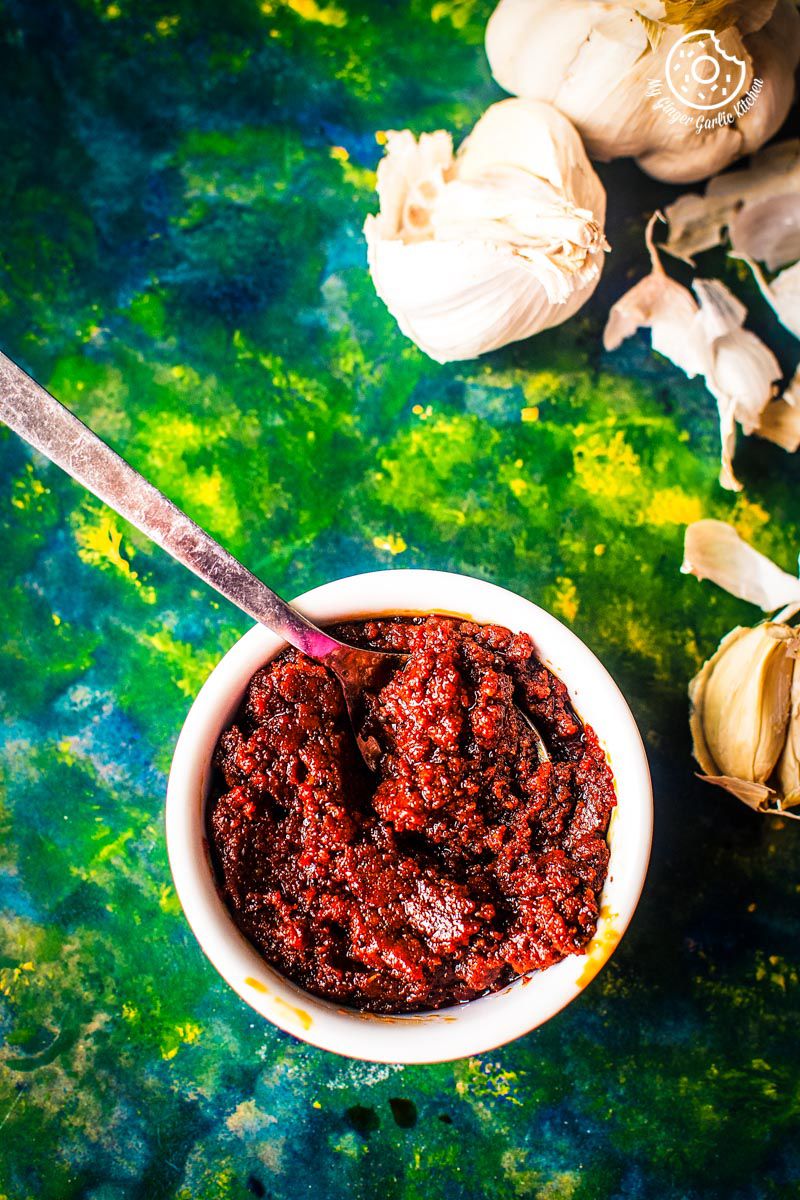 there is a bowl of rajasthani lehsun ki chutney with a spoon in it