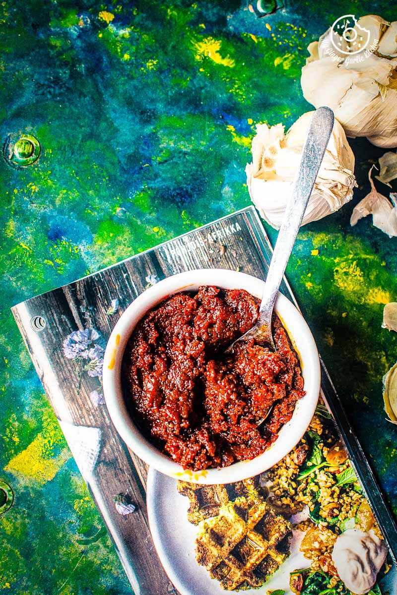 there is a bowl of rajasthani lehsun ki chutney on a plate with a spoon