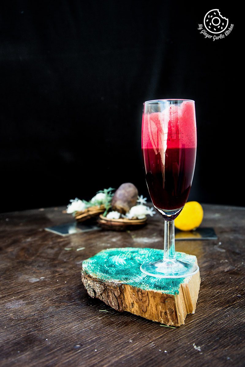 a glass of detox heart beet juice sitting on a wooden table