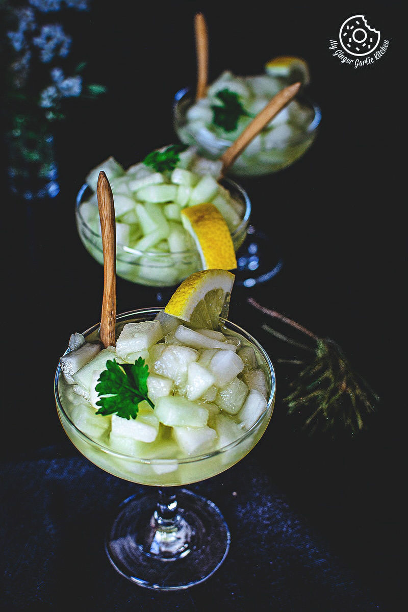 three glasses of kharbuje ka panna with lemon slices and wooden spoons