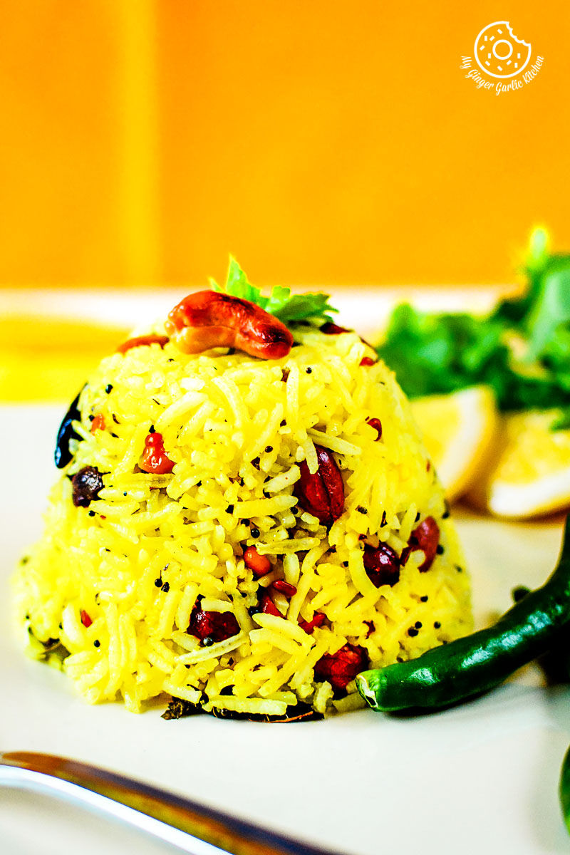 a plate of south indian lemon rice with a side of vegetables