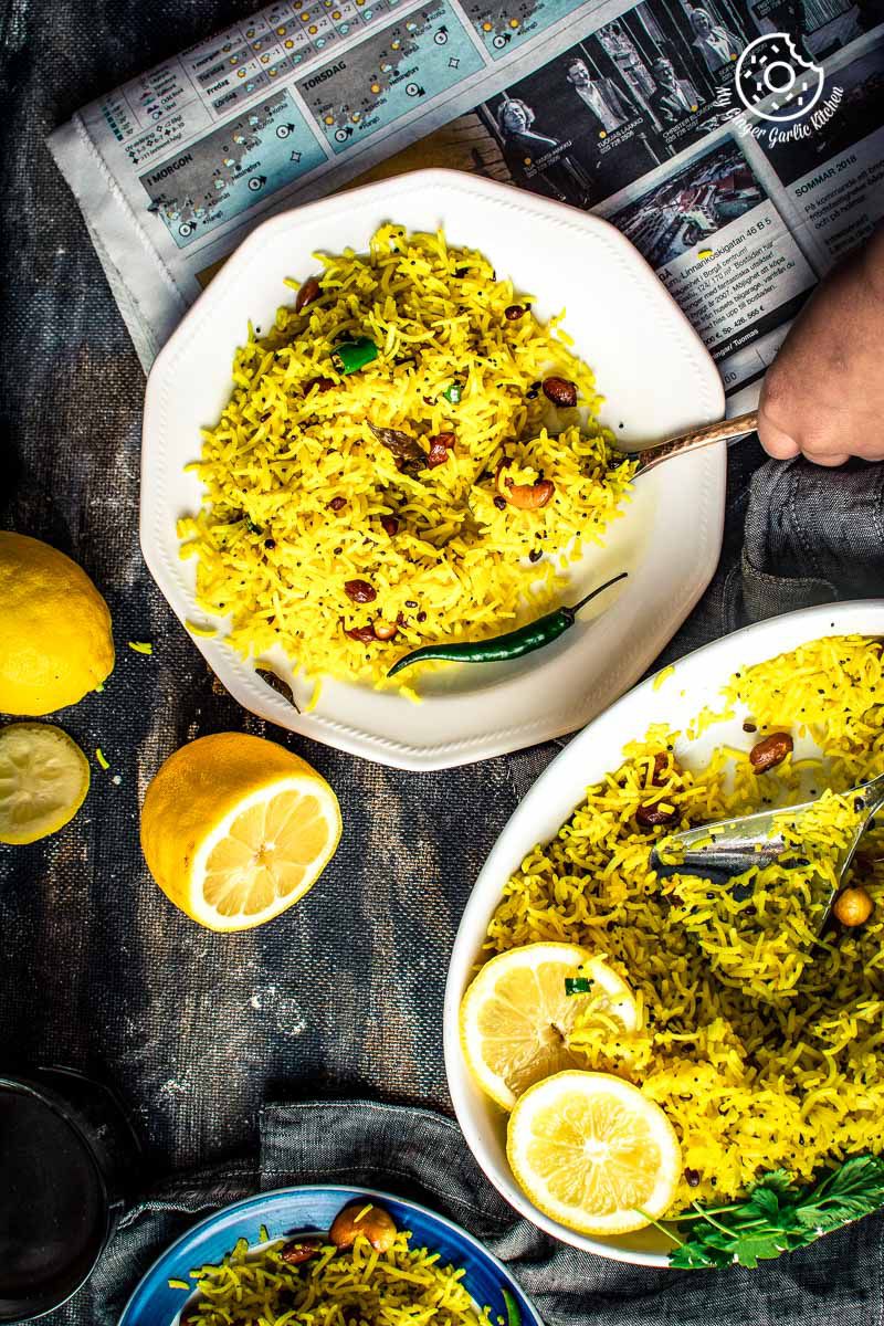 a bowls of south indian lemon rice with lemons on side