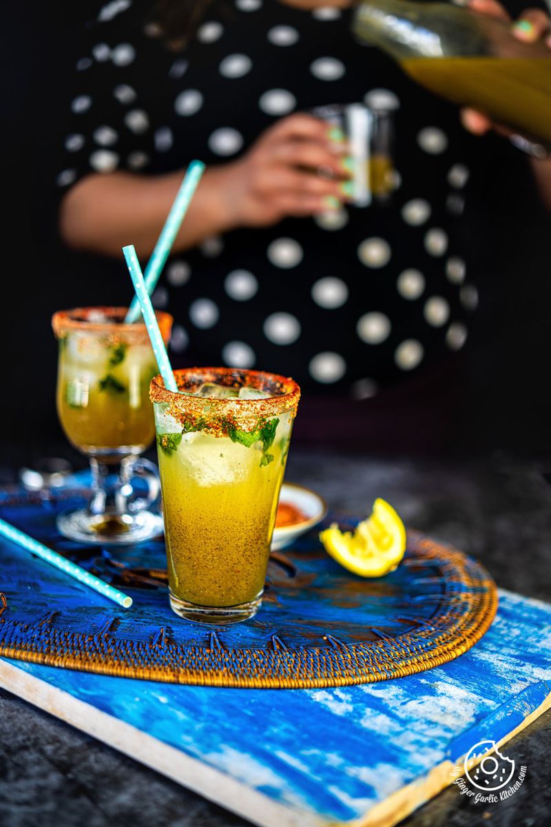 a female holding a aam panna glass