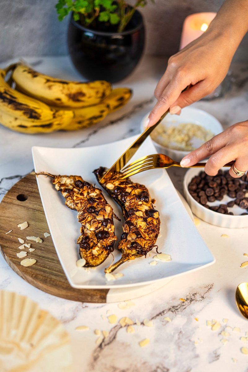 Air Fryer Banana with peanut butter, chocolate chips, and toasted almonds served on a platter for an easy dessert.