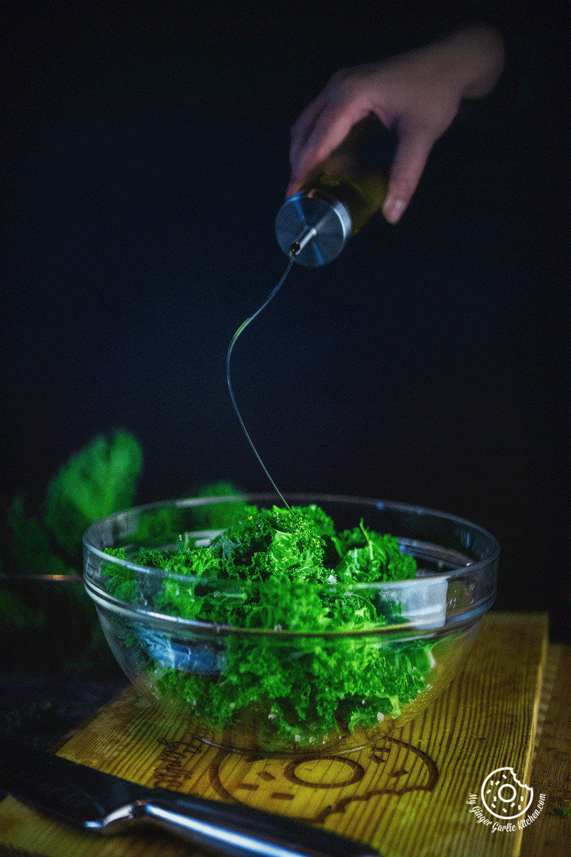 image of oil pouring over Kale leaves