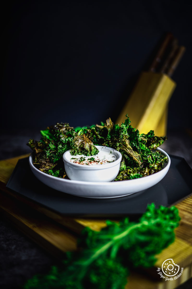 air fryer kale chips in a white plate with dip bowl