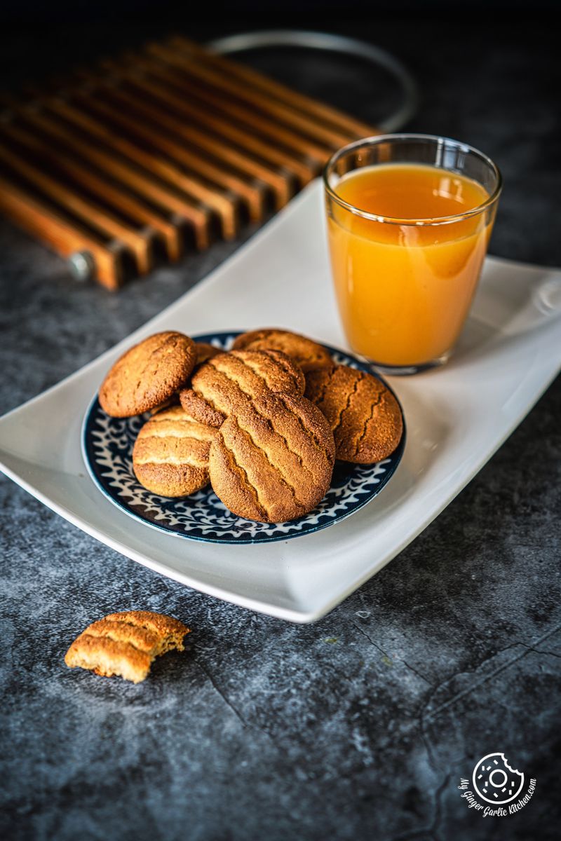 almond flour cookies plate in a white tray with a glass of orange juice