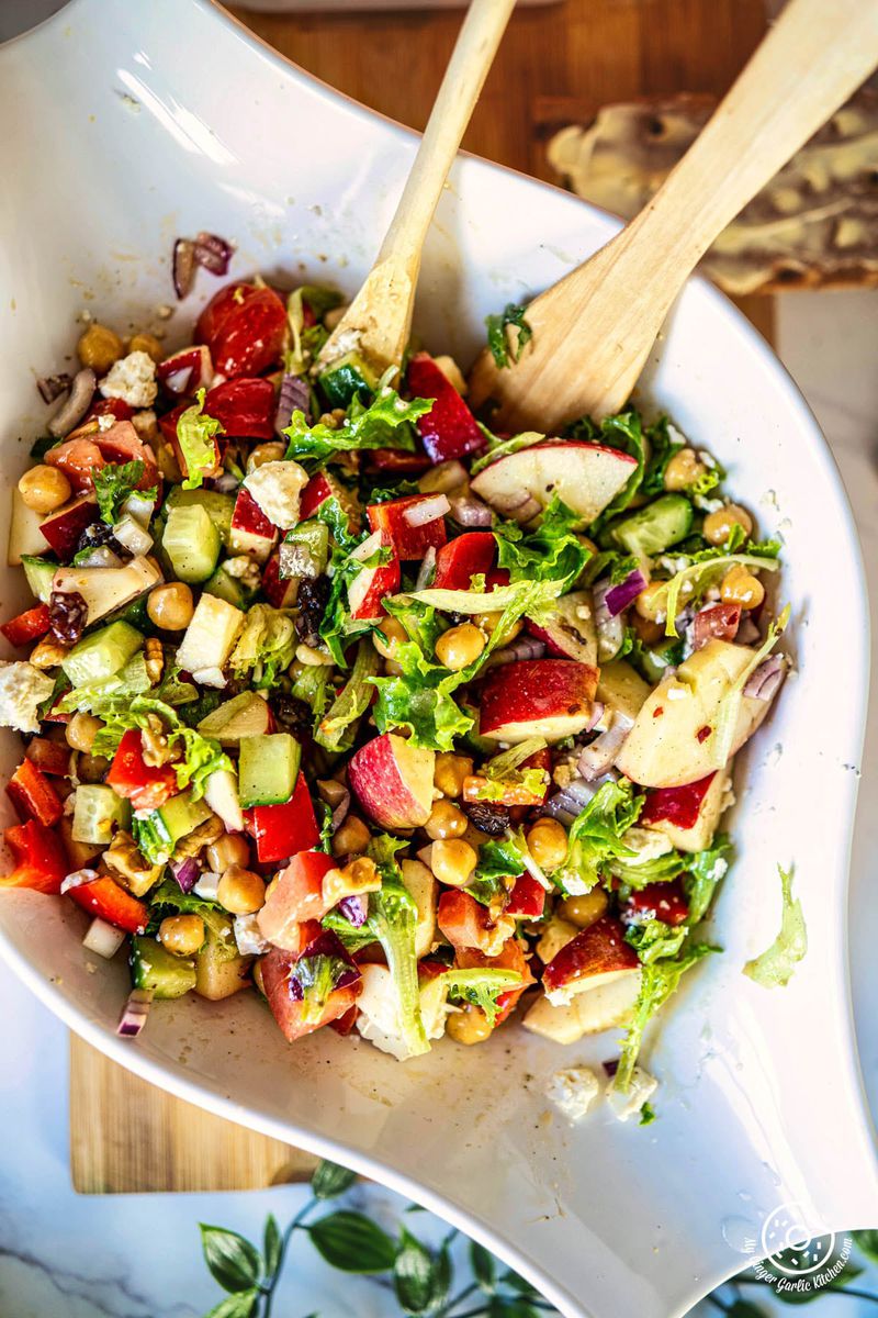 closeup photo of a bowl of apple salad with apples, cucumbers, tomatoes and cucumbers in it