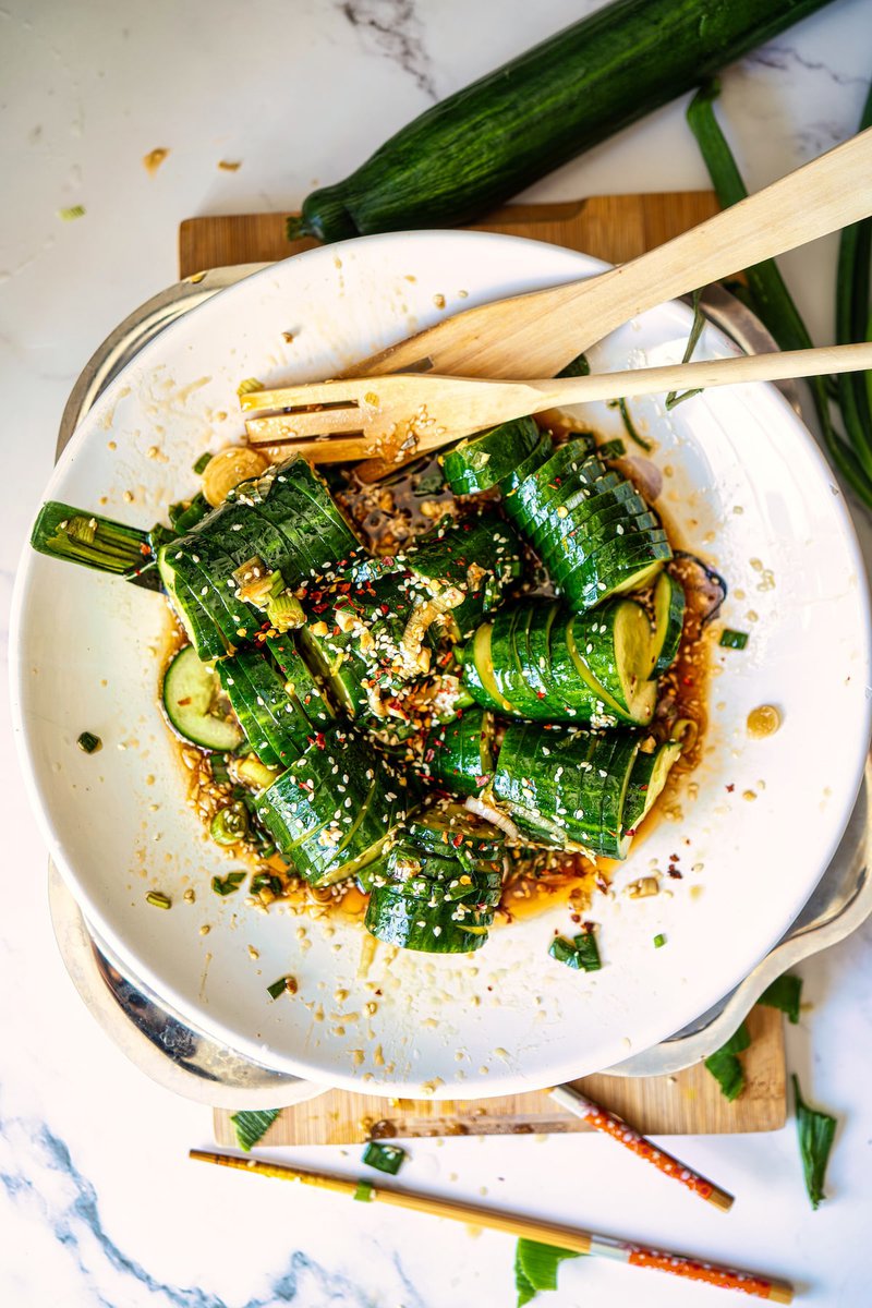 Overhead view of Asian cucumber salad with sesame seeds in a white bowl.