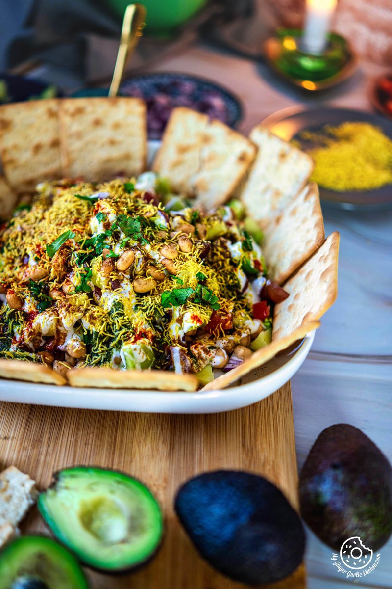 closeup photo of a plate of avocado chaat with crackers and avocado on the side