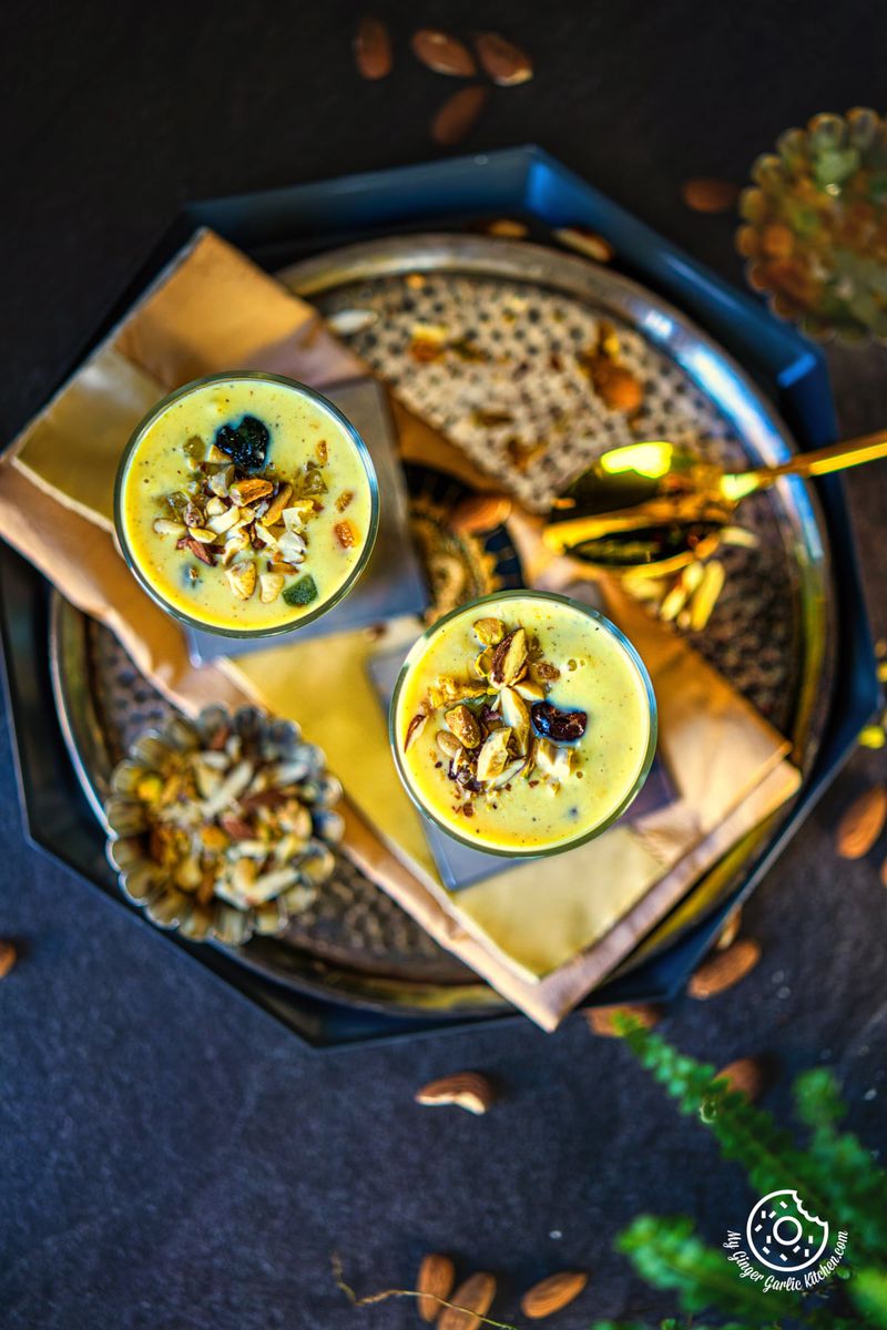 overhead photo of a plate with two glasses of badam milkshake on it