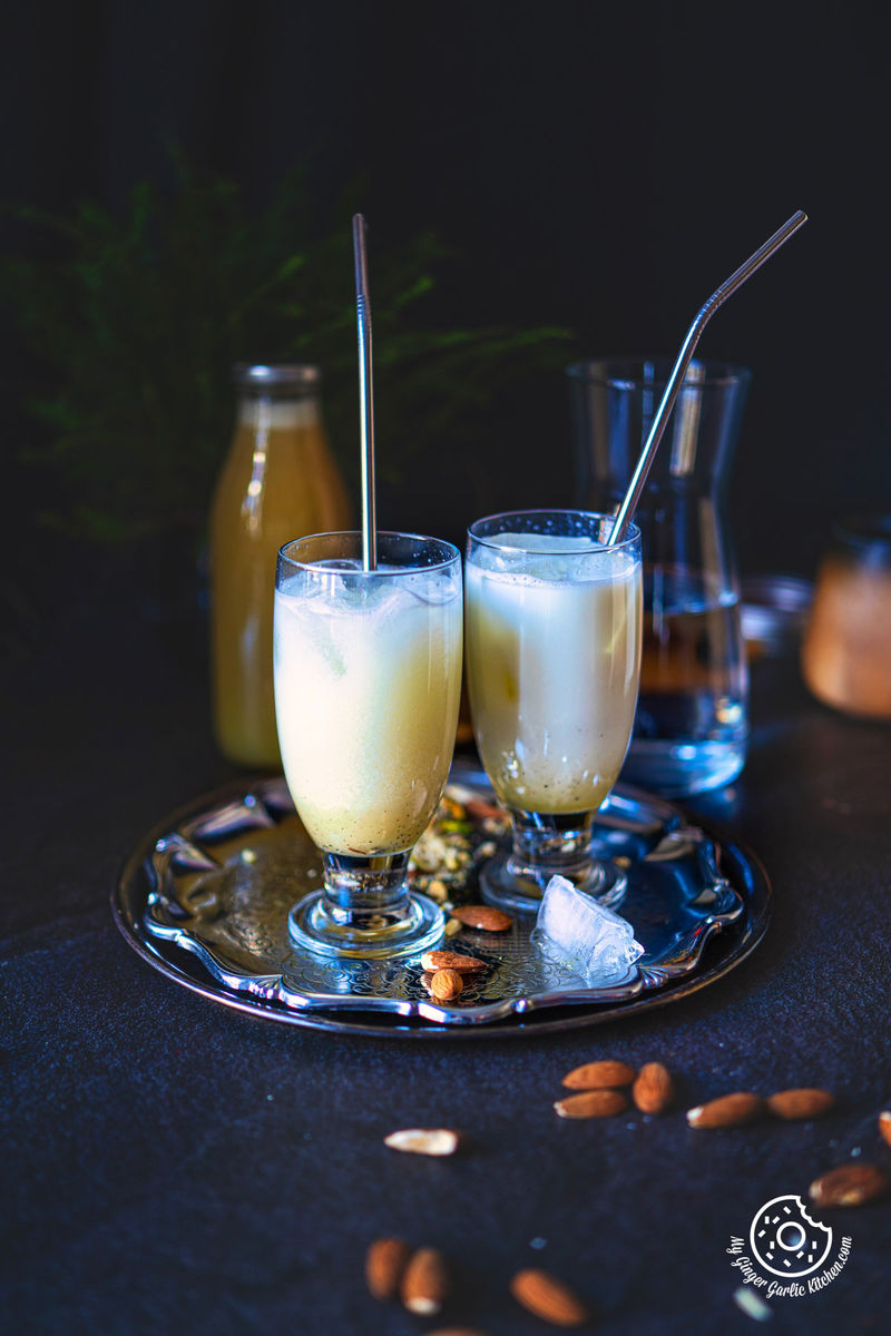 photo of two glasses of almond sharbat and almonds on a tray