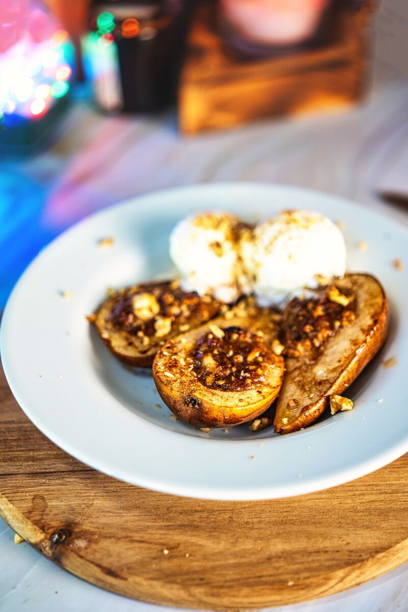 Plated baked pears with goat cheese walnut filling and vanilla ice cream, elegant pear dessert for parties