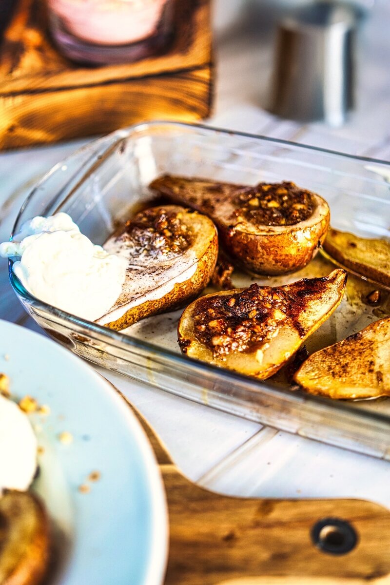 Baked pears stuffed with goat cheese and walnuts in a glass baking dish, oven-baked pear dessert recipe