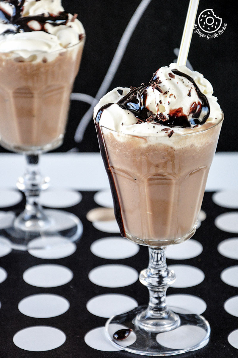 two glasses of banana coffee shake with chocolate sauce and whipped cream