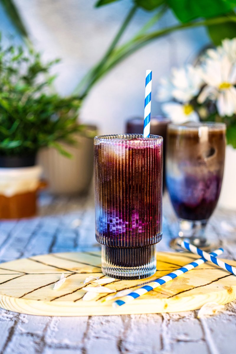 Blueberry iced latte made with homemade blueberry syrup, espresso, ice, and oat milk with beautiful purple coffee layers