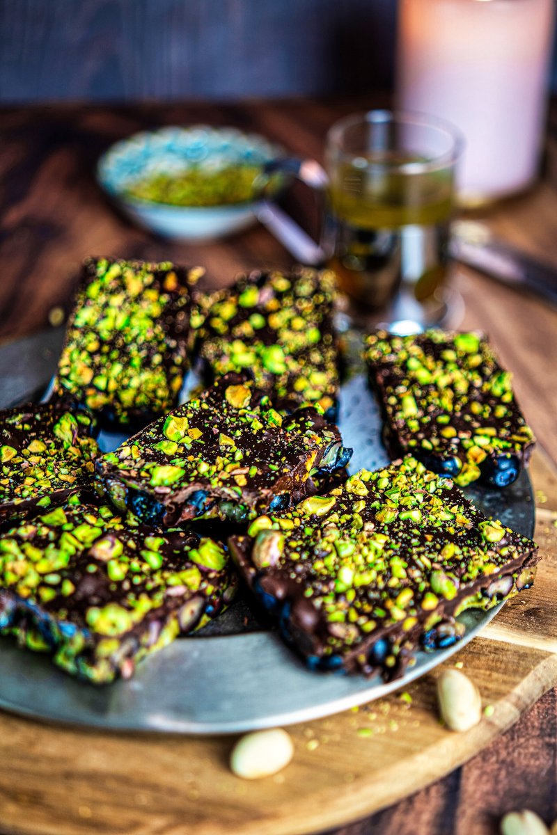 Blueberry Pistachio Chocolate Bark pieces served on a plate, an easy no-bake dessert with fresh blueberries, dark chocolate, and roasted pistachios.