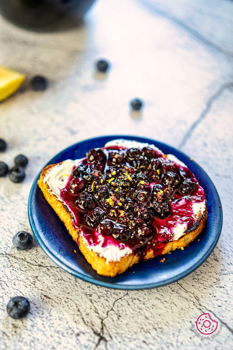 closeup of blueberry toast in a blue plate with some fresh blueberries