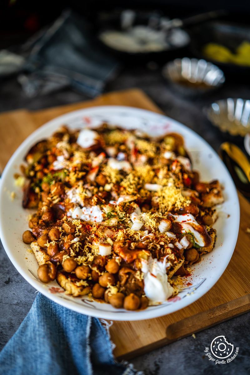 bread chana chaat served in a white plate kept over a wooden board