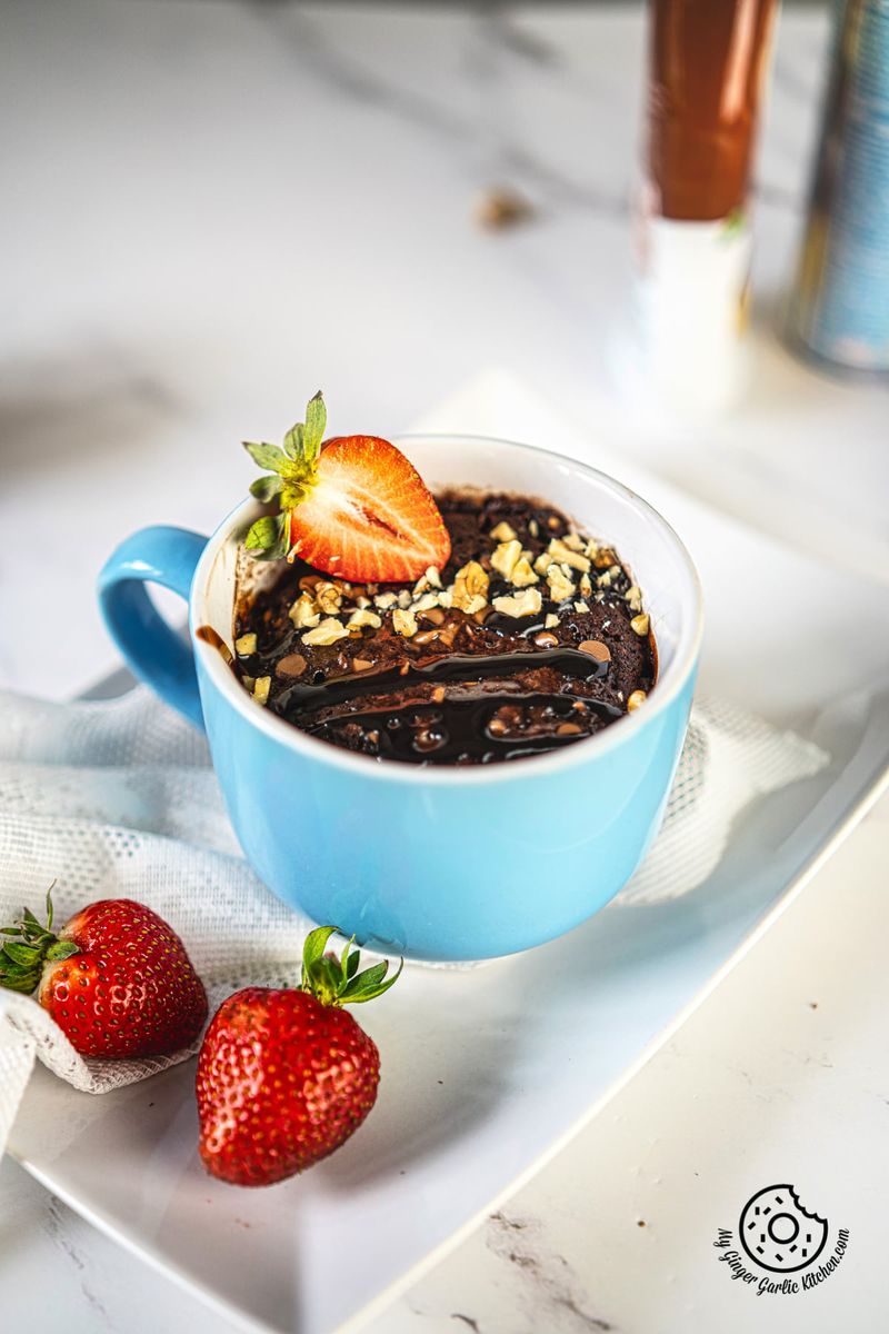 a blue mug of microwave mug brownie on a white tray