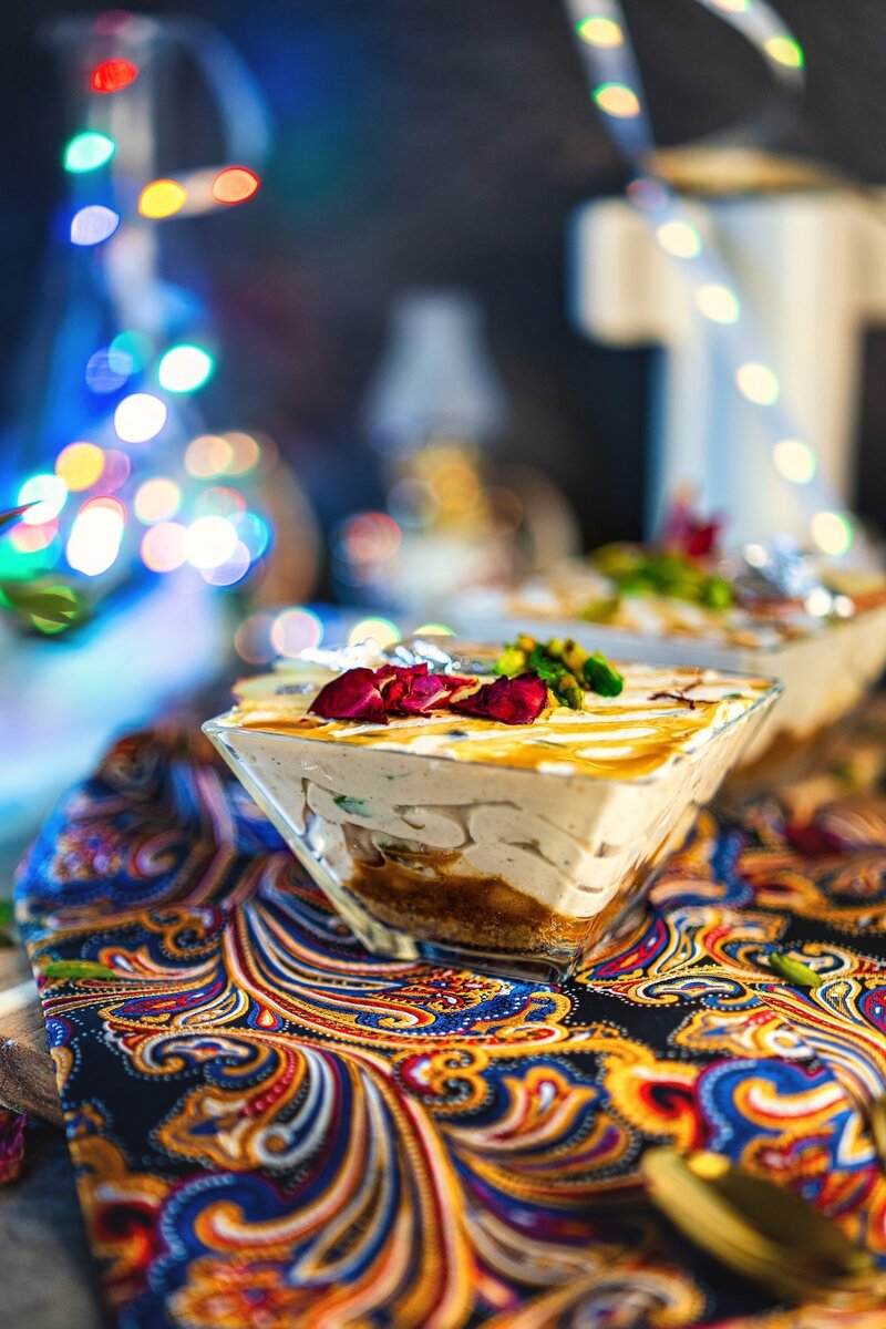 No bake Caramel Apple Shrikhand served in glass bowls with cookie base, creamy yogurt layers, and festive Diwali lights.