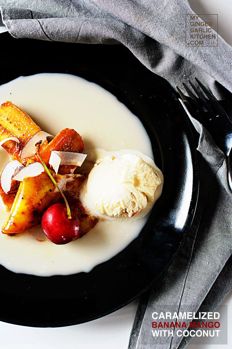 a plate of caramelized banana mango with coconut with ice cream and cherry on it