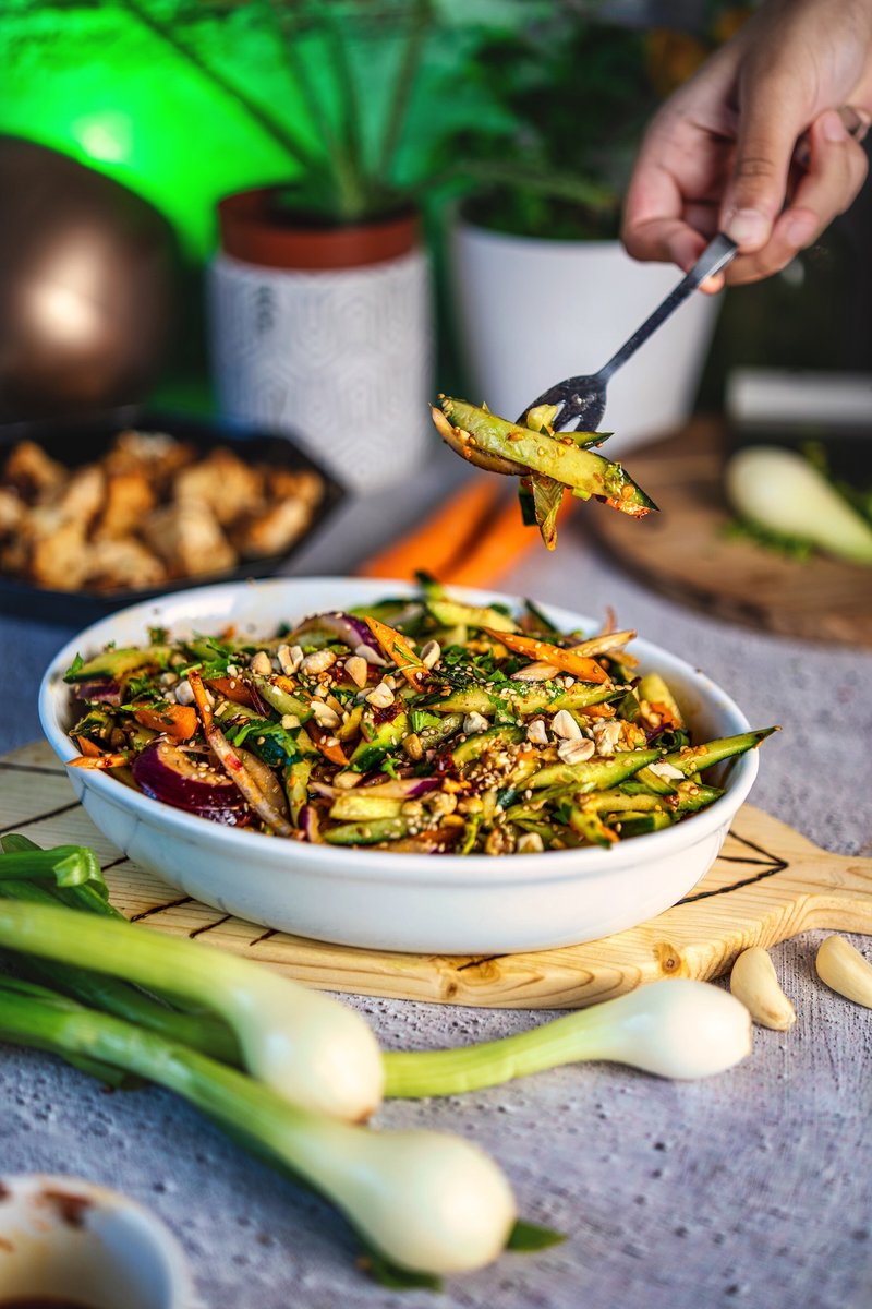 Asian-inspired carrot cucumber salad with chili crisp, roasted peanuts, sesame seeds, and fresh cilantro