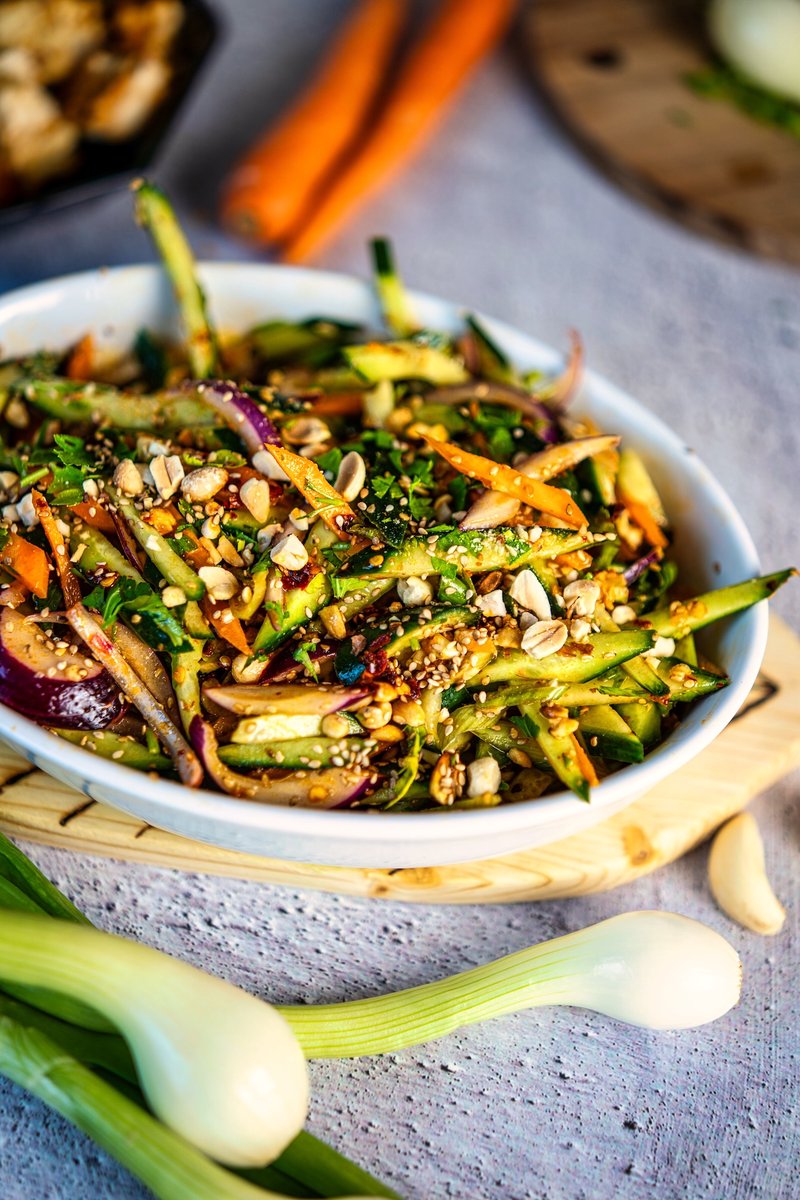 Crunchy cucumber carrot salad with roasted peanuts, sesame seeds, chili crisp, red onion, and fresh cilantro