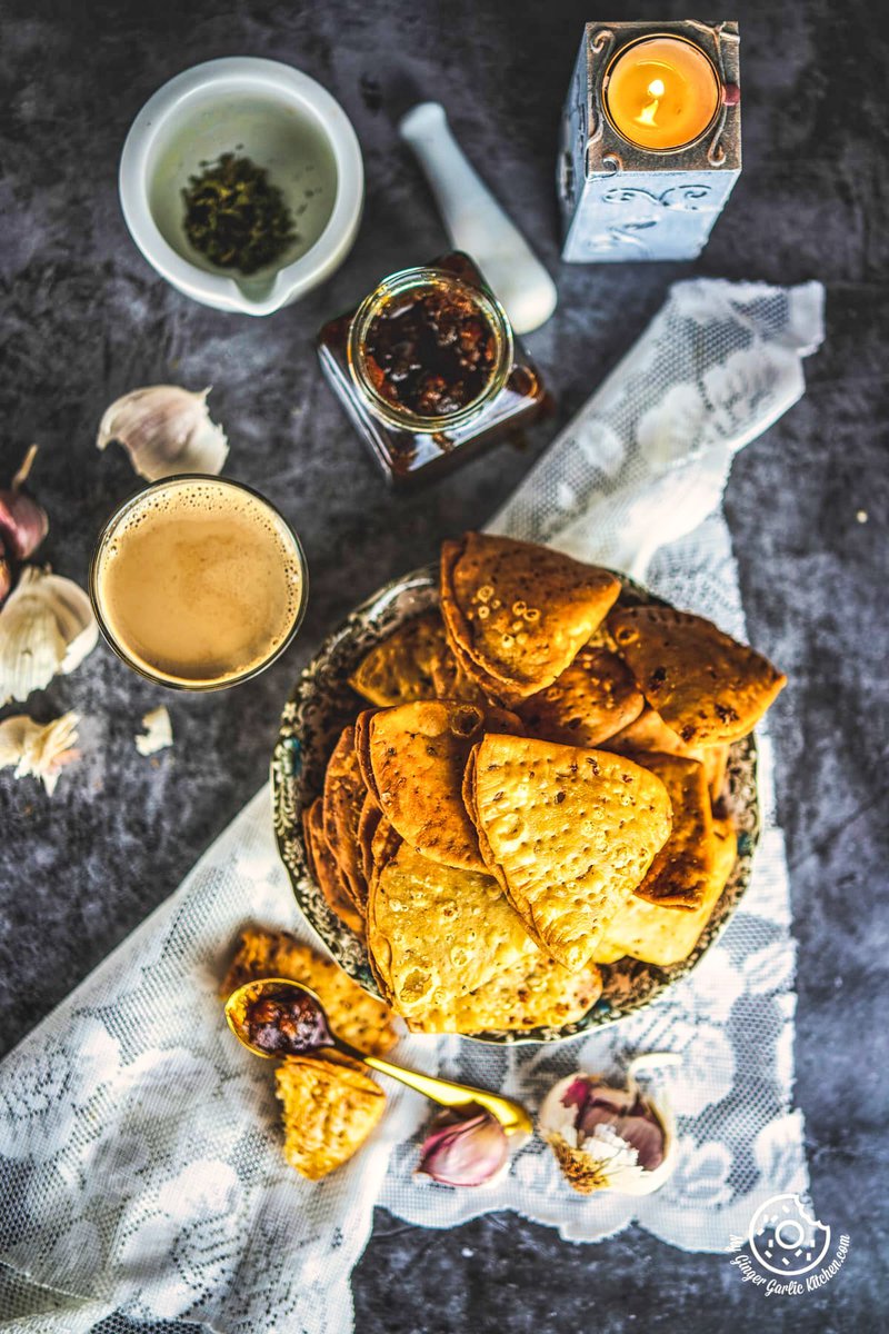 Overhead Image of Cheese Garlic Masala Mathri in a bowl along with a coffee glasss