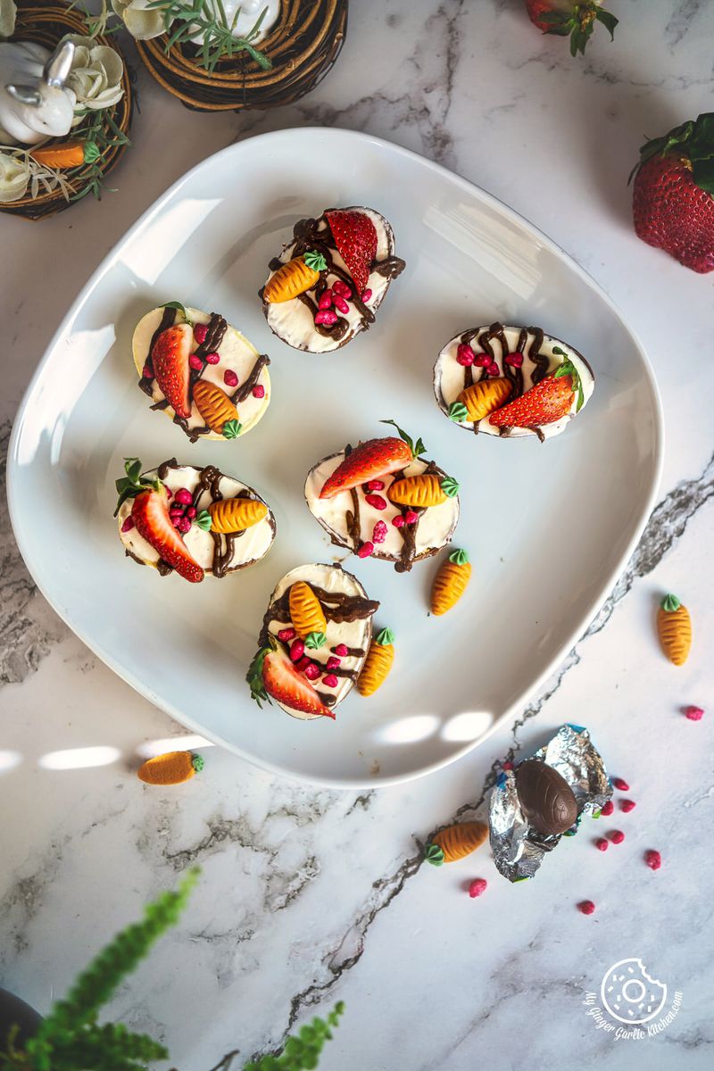 overhead view of 6 cheesecake filled easter eggs on a white plate