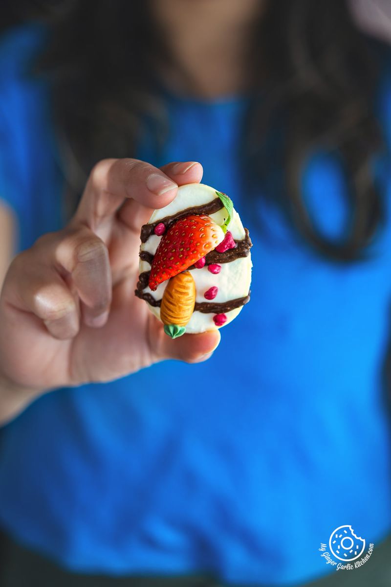 a close up of female holding one cheesecake filled easter egg